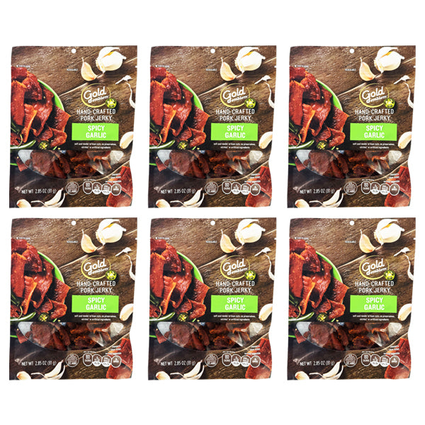 Six packs of Gold Emblem Spicy Garlic Hand Crafted Pork Jerky (2.85oz each) are arranged in two rows of three. The preservative-free packaging features garlic cloves and herbs.